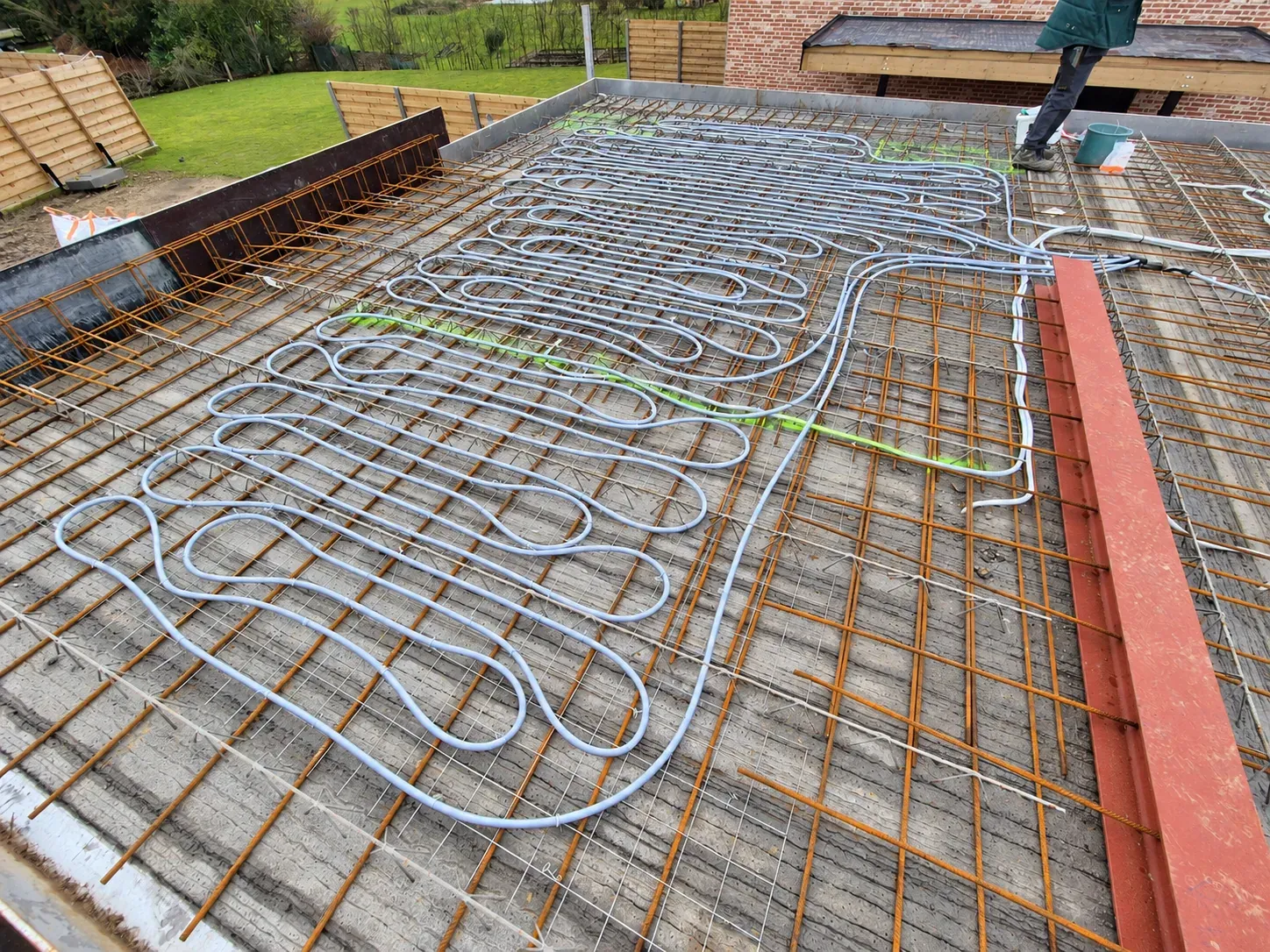 Leidingen voor betonkernactivering tussen de wapening van een vloerplaat, klaar om te storten