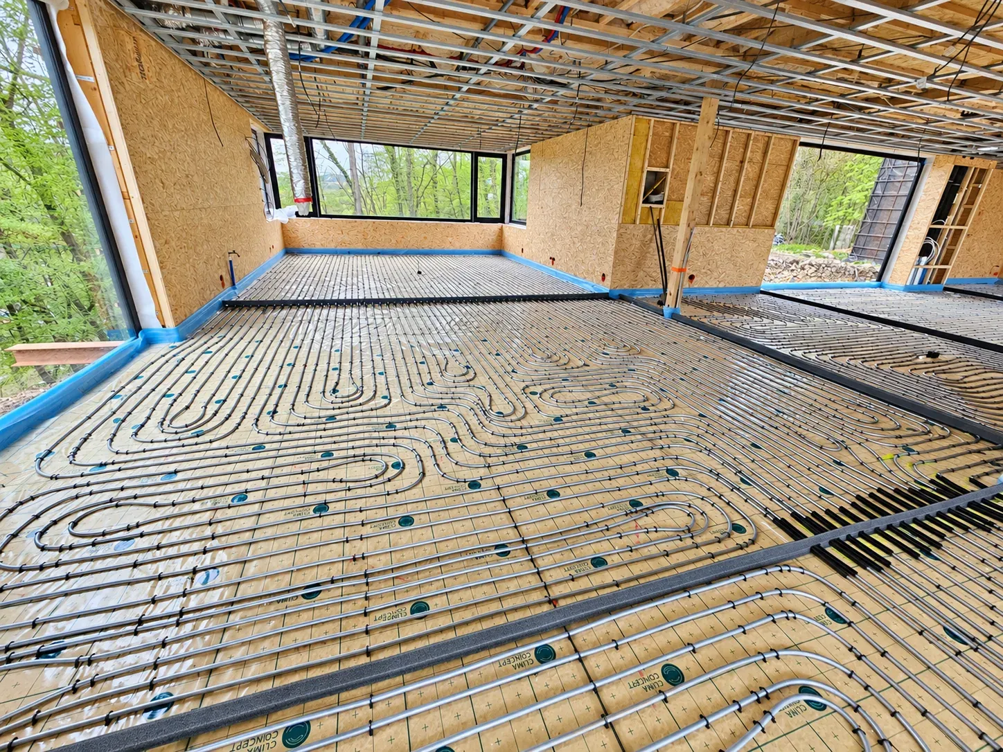 Vloerverwarmingsbuizen in lussen op Clima Concept-isolatieplaten in een nieuwbouwwoning met grote ramen