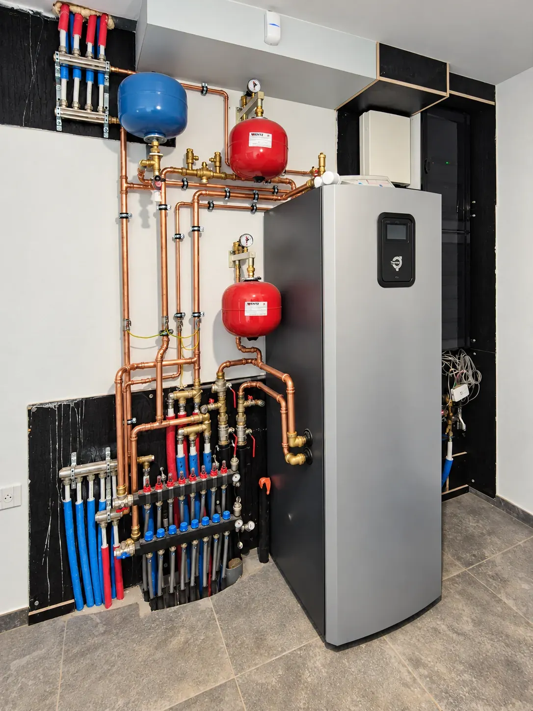 Thermia binnenunit van een geothermische warmtepomp met aangesloten leidingwerk en verdelers